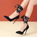 Women's black platform court shoe with pointed toe and lace ankle strap on a 12cm heel.
