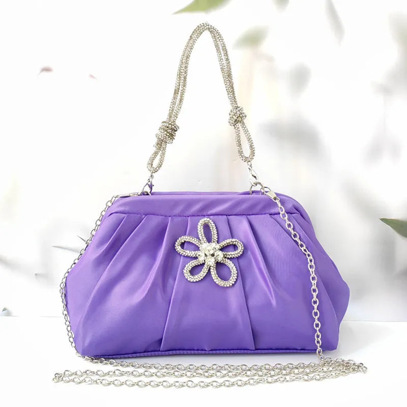 Soft shell-shaped lavender purple women's shoulder bag with fold, diamond, and chain details.