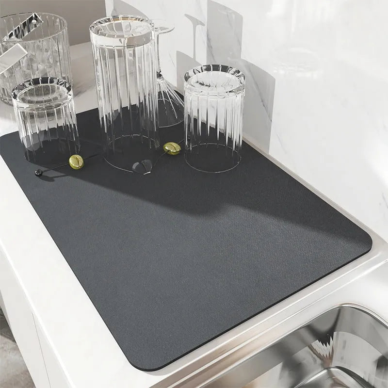 Black square kitchen drain drying mat with anti-slip rubber backing on a countertop