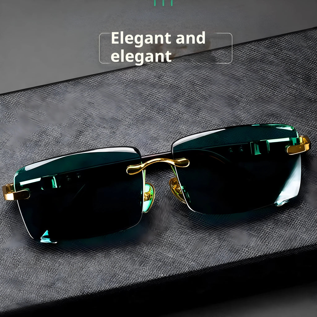 Frameless dark green crystal sunglasses with metal arms on a table next to their hard case.