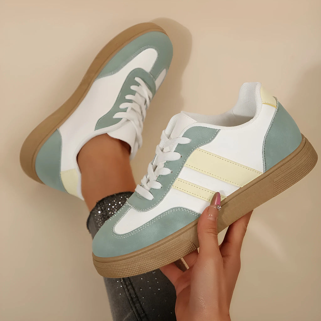 Green women's retro sports pumps with cross straps, leather stitching, and a round toe on a rubber sole.
