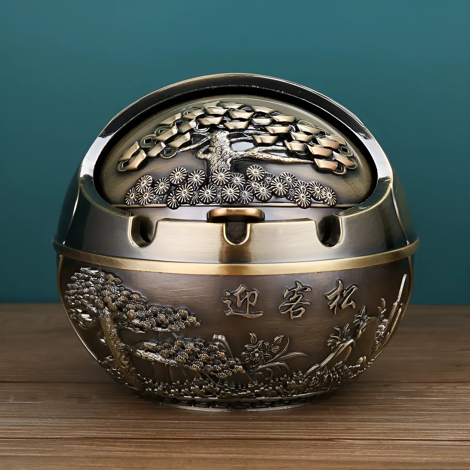 Bronze alloy ashtray with decorative fortune tree design and smoke extinguishing slot.