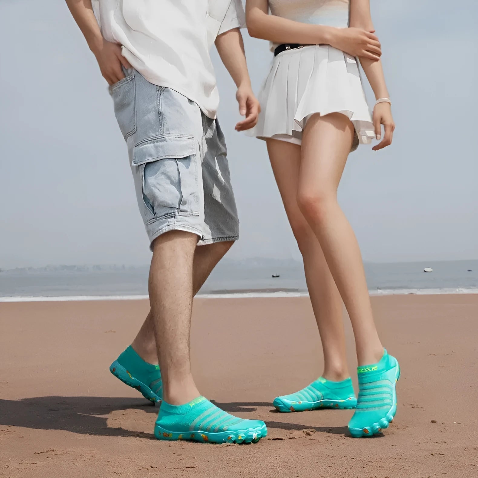 Women's camouflage pattern water shoes with Flyknit upper and flat rubber sole on a rocky shore.