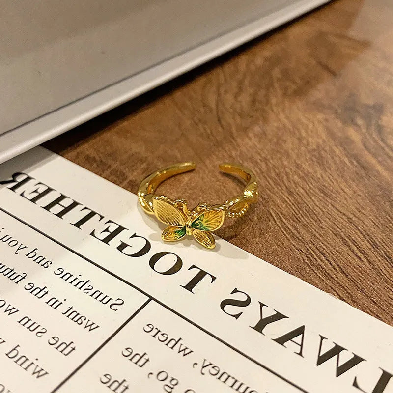 Creative butterfly design women's ring in copper with oil drip finish, showing an open loop style.
