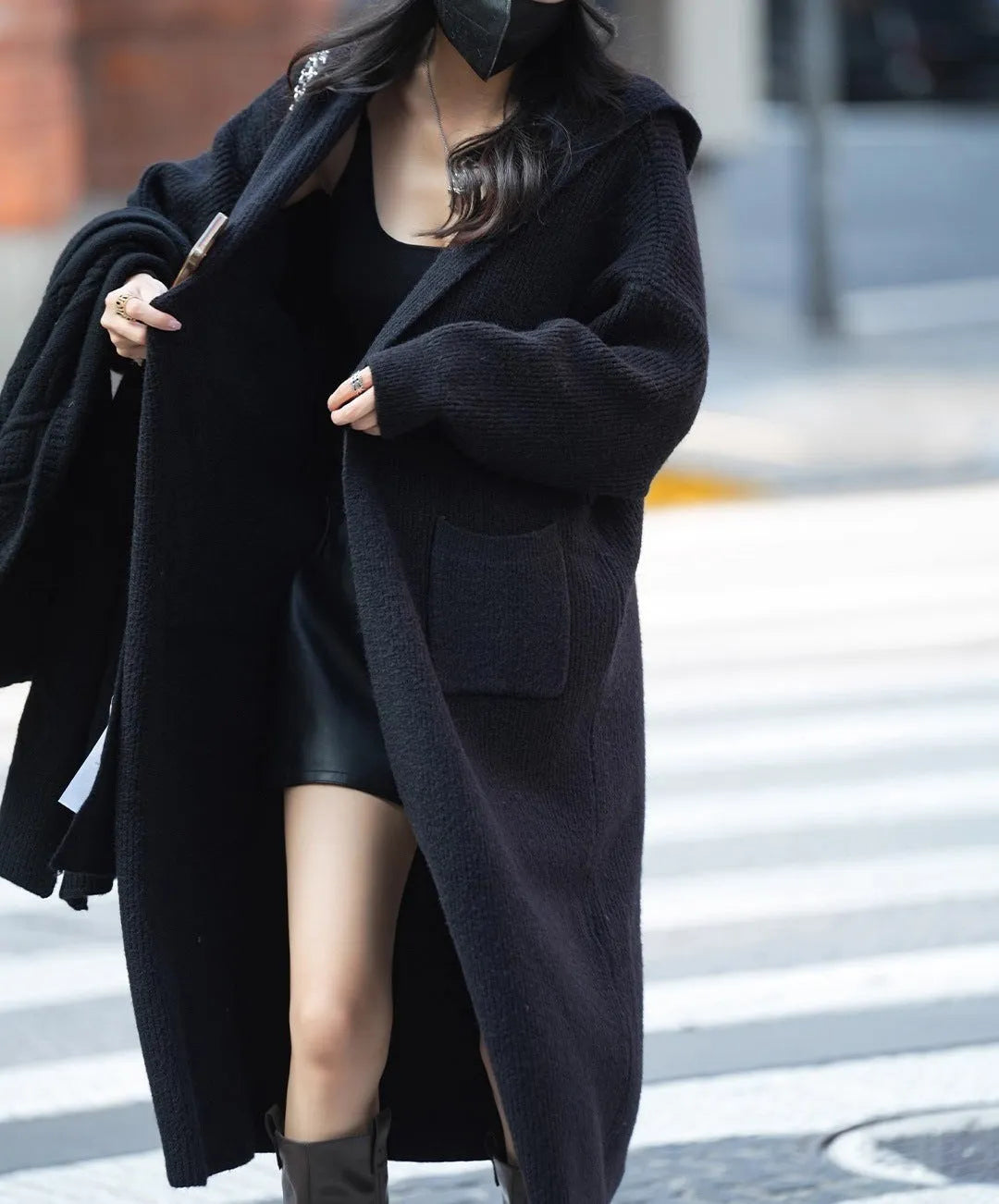 Long grey knitted hooded cardigan trench coat on a hanger, showing loose fit and length.