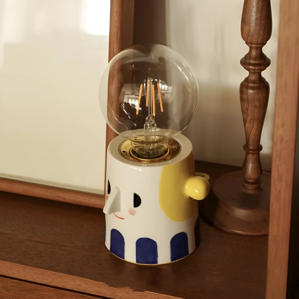 Handmade white ceramic table lamp with a spherical ball-shaped shade on a wooden surface.