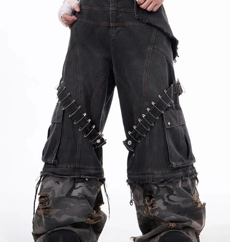 Men's grey jeans with camouflage splicing design and pin and ribbon details on the legs.