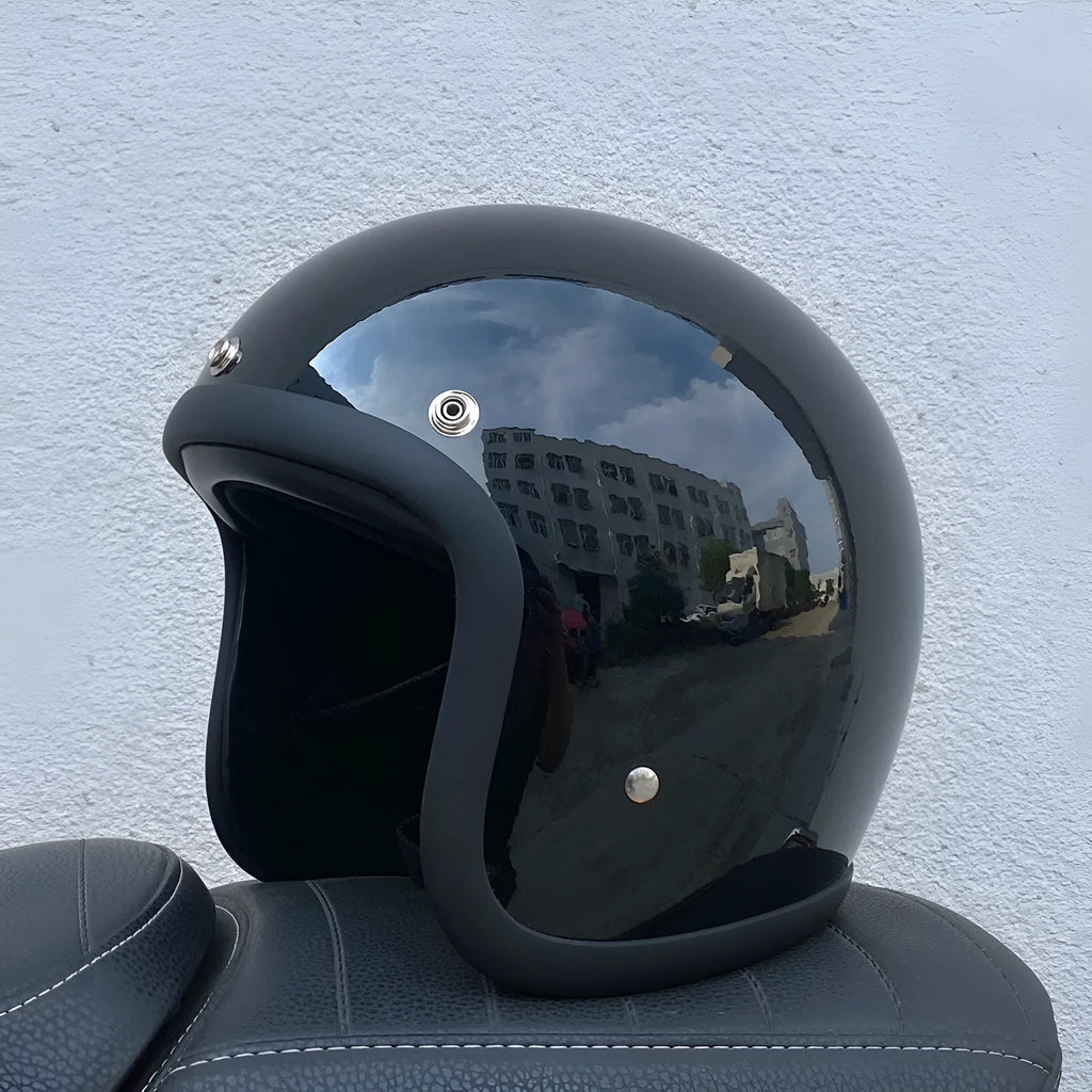 Retro-style open-face motorcycle helmet in fibreglass, shown in a choice of colours including Cement Grey and Matte Black Flower.