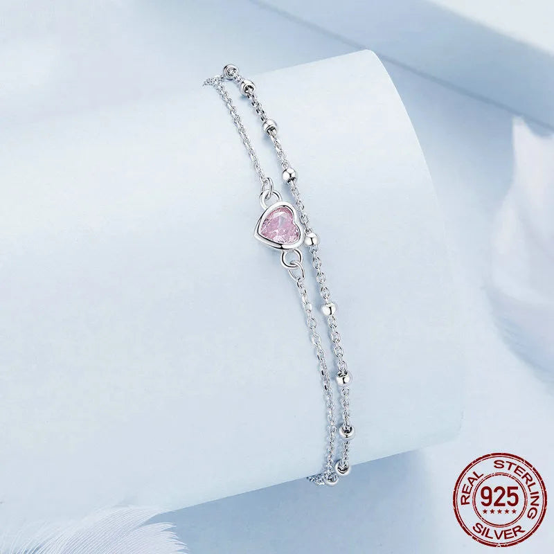 Women's sterling silver bracelet with a small heart-shaped pendant on an adjustable chain.