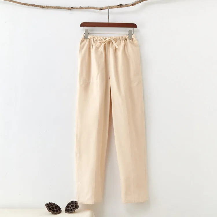 Men's beige pure cotton casual trousers with drawstring waist and belt on a neutral background.
