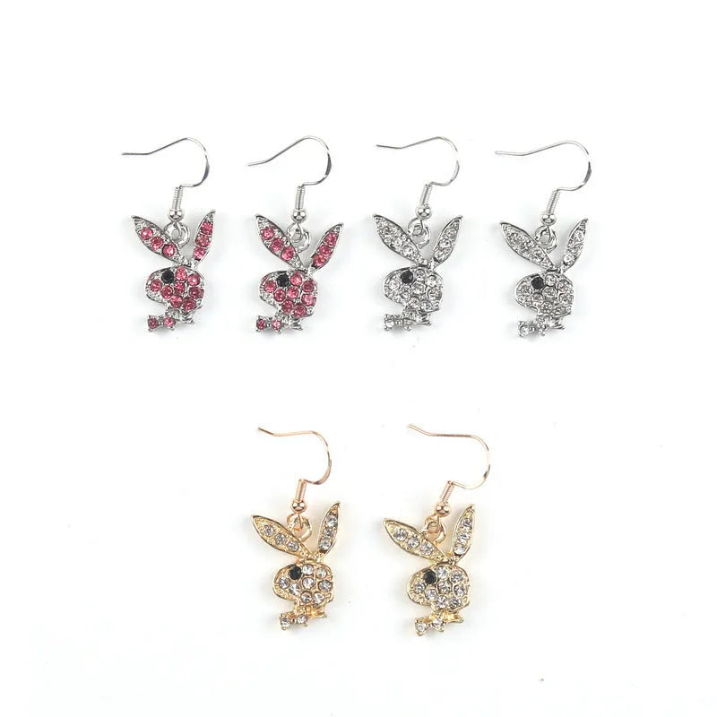 Close-up of rabbit-shaped stud earrings with sparkling cubic zirconia stones in gold, pink, and silver finishes.