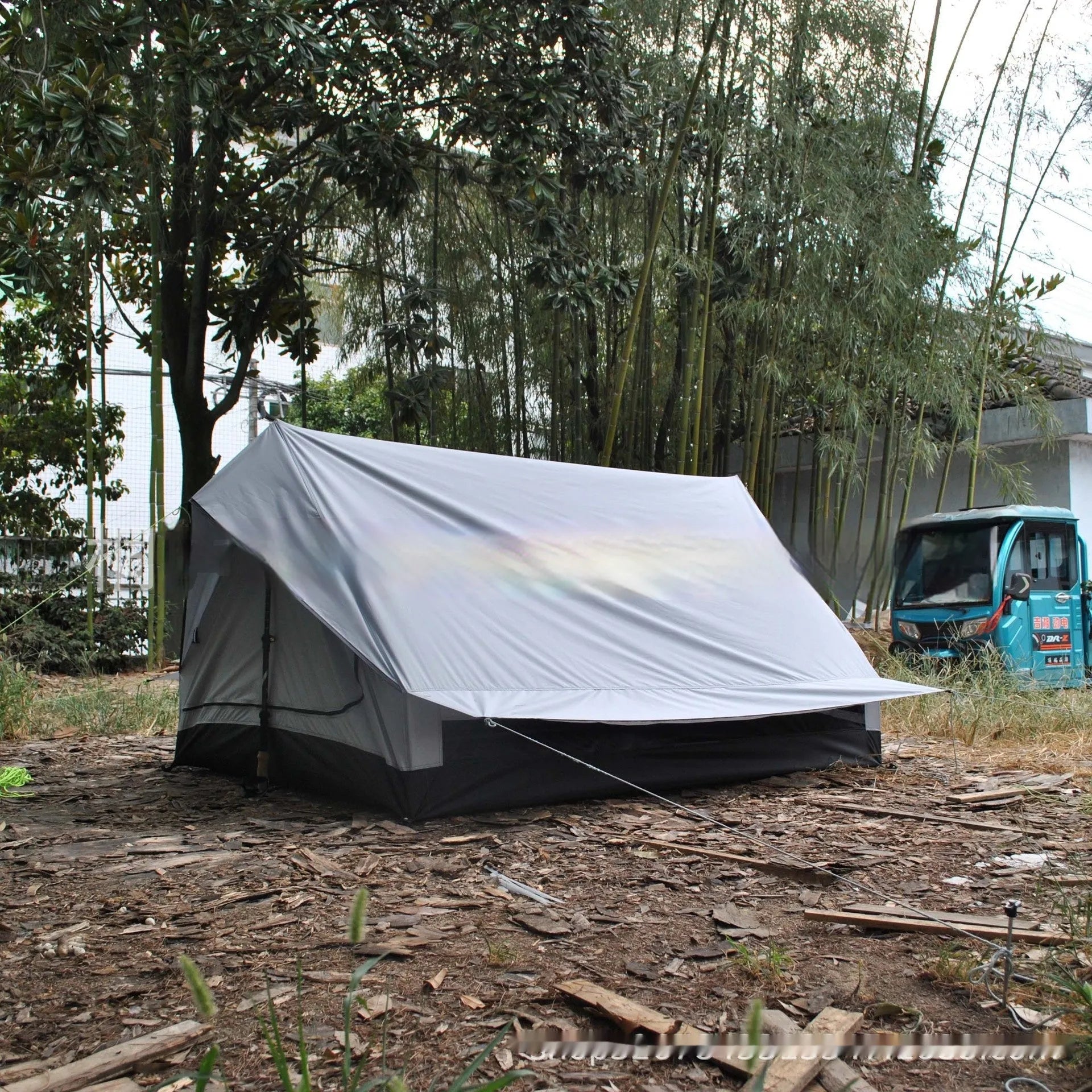 Brown and white pole-free A-line cabin tent for 2-3 people shown pitched with hiking poles.