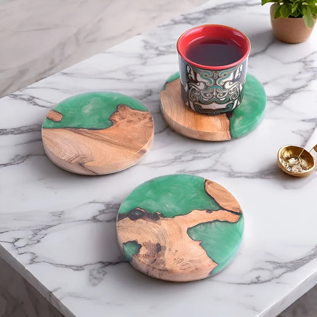 Set of four solid-colour wooden coasters in irregular round and square shapes on a wooden table.
