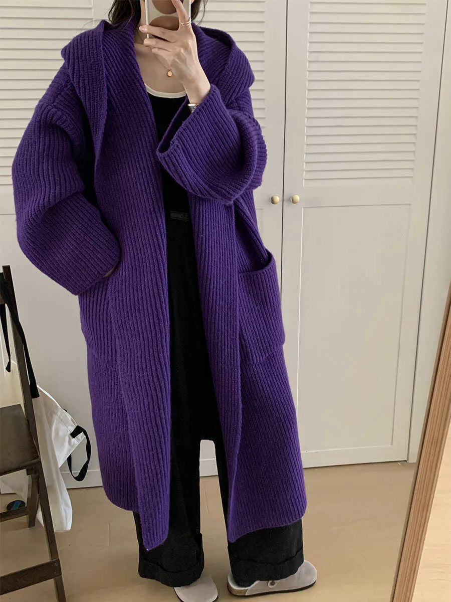 A woman wearing a loose, milky white hooded cardigan coat with raglan sleeves.