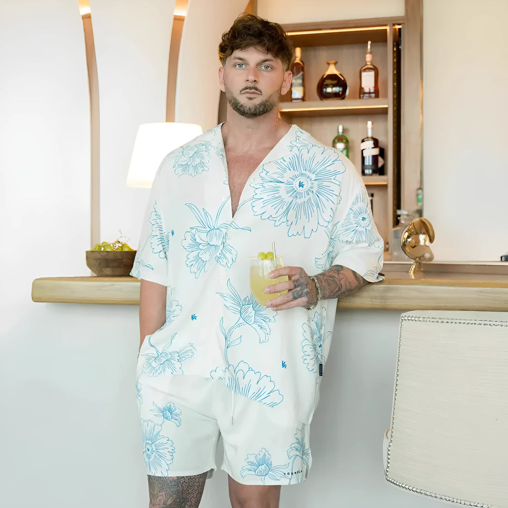 Men's loose-fit short sleeve top with floral print in light colour, laid flat.
