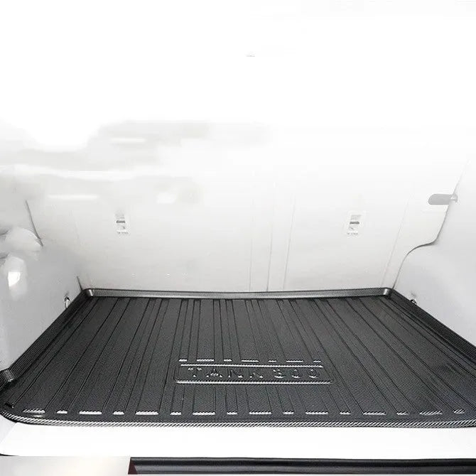 Black TPE car boot liner mat with a carbon fibre pattern texture, laid flat.