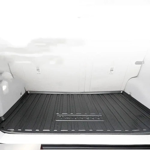 Black TPE car boot liner mat with a carbon fibre pattern texture, laid flat.