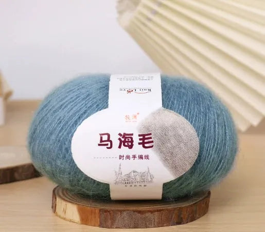 Ball of mohair yarn for DIY scarf knitting in one of 34 colours, including white, pink, blue, and green.