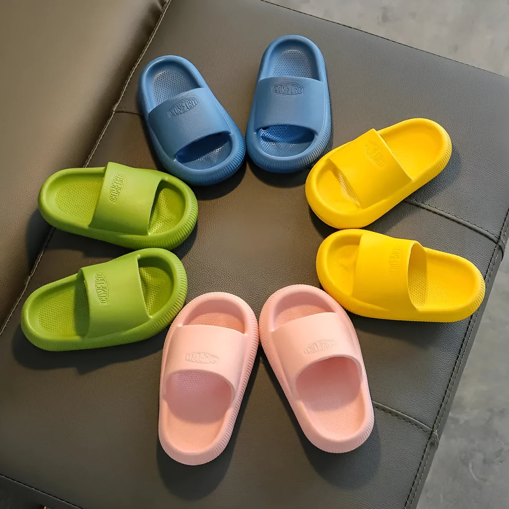 Colourful children's EVA slippers with textured sole, shown in blue, green, orange, pink, and yellow.