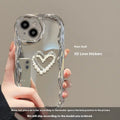 Silver grey silicone phone case for iPhone 14 Pro Max with three-dimensional heart and pearl chain bracelet.