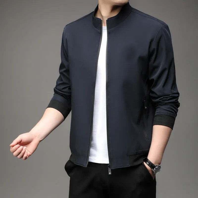 Man wearing a loose-fit black casual autumn jacket with a lapel and zippered pockets.