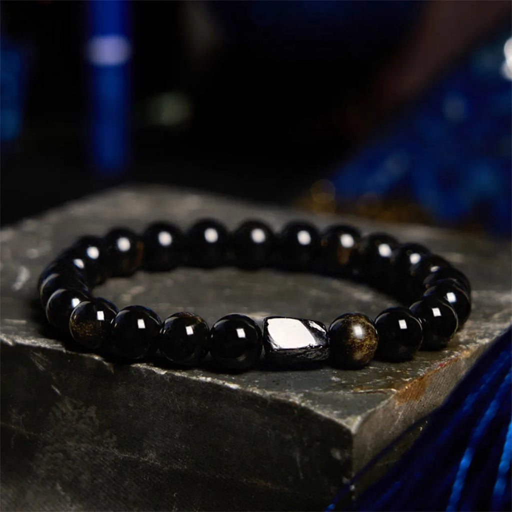Natural obsidian single ring bracelet with constellation modelling on a wrist.