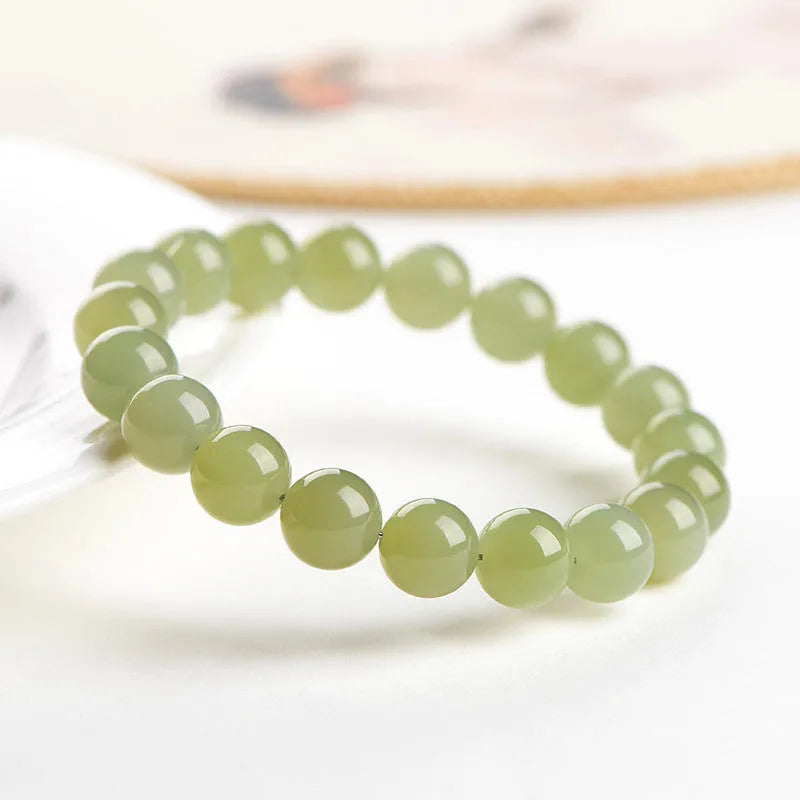 Polished Hetian jade ball bracelet on wrist, showing ice-like clear beads in available 4mm, 6mm, 8mm, and 10mm sizes.