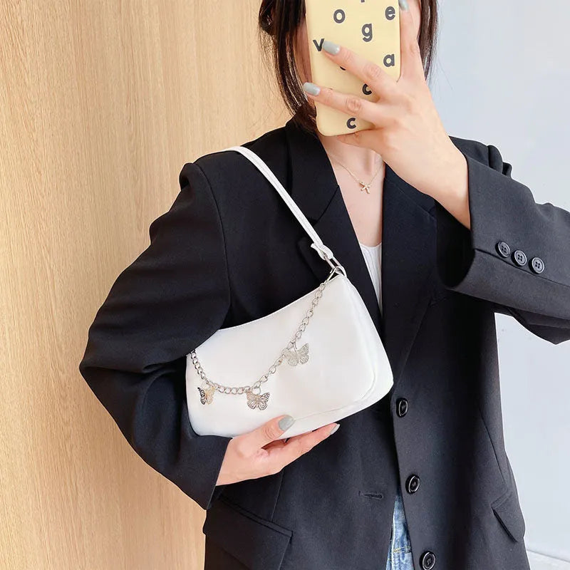Women's black PU leather butterfly chain underarm bag showing crossbody wear with retro styling