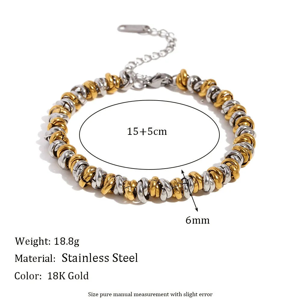 Gold geometric stainless steel jewellery set for women, showing earrings, necklace, and bracelet with electroplated finish.