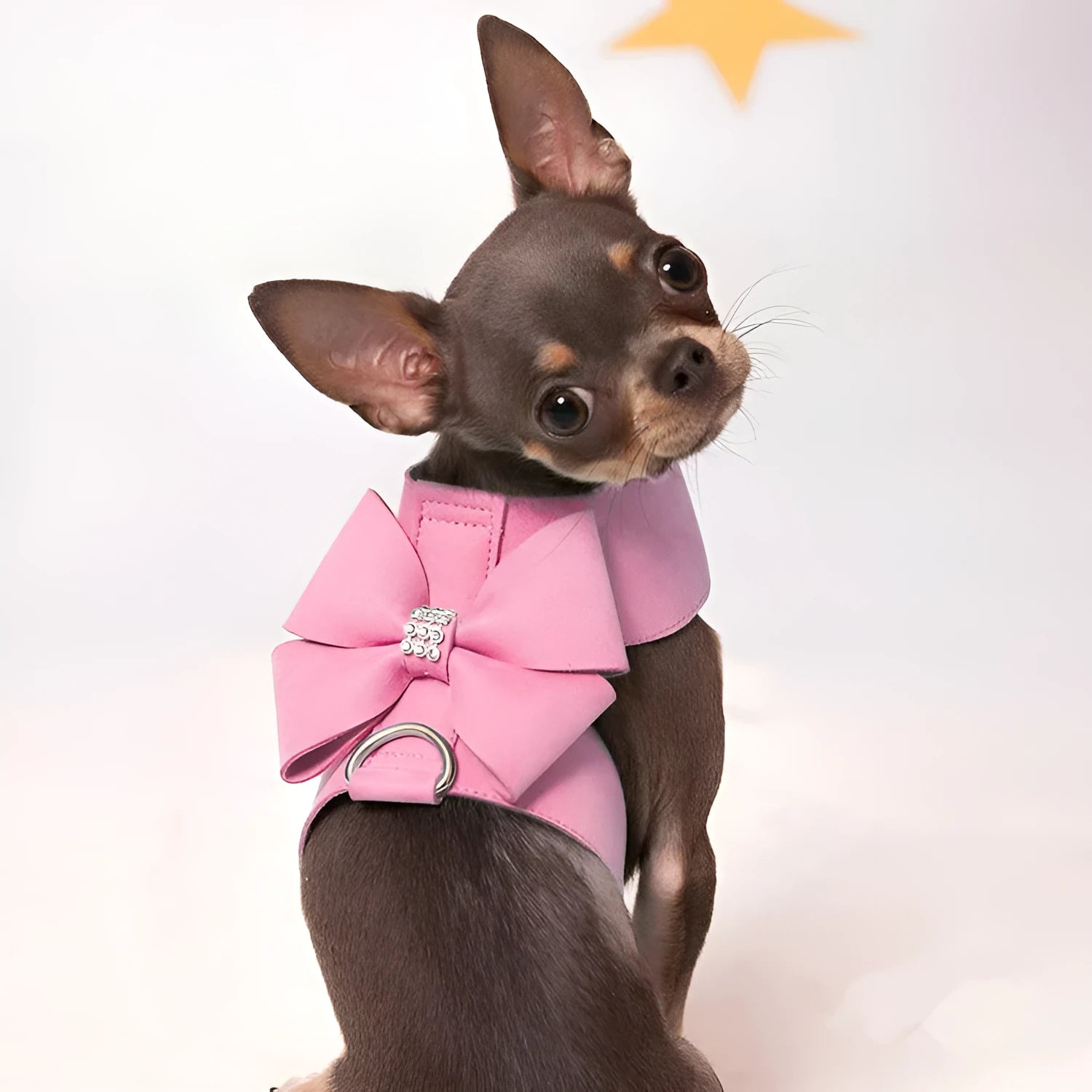 A pink microfiber dog chest strap with a white bowknot, showing the adjustable size buckles.