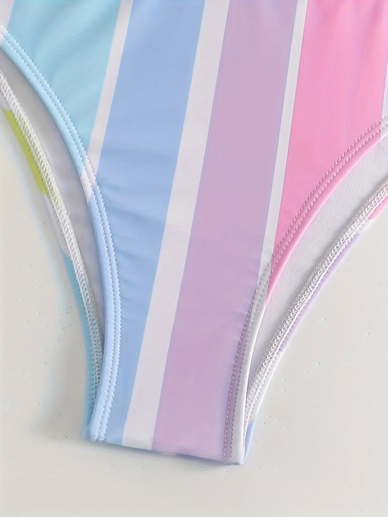 Women's striped two-piece bikini on a hanger, showing sporty briefs with spandex lining and matching top.