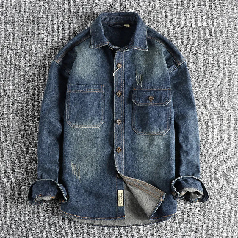 Man wearing a light blue vintage washed denim shirt with a loose fit and long sleeves.