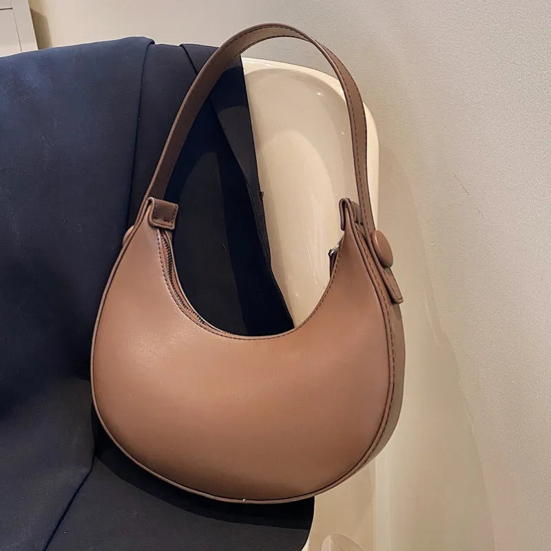 Women's retro brown dumpling-shaped PU leather shoulder bag showing front and internal zipper pocket.