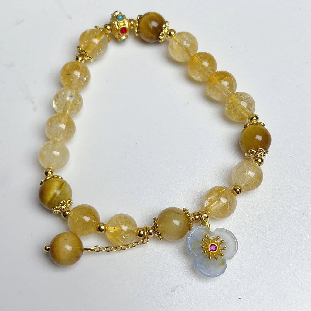 Close-up of a handcrafted citrine crystal bracelet for women with a floral tassel pendant.