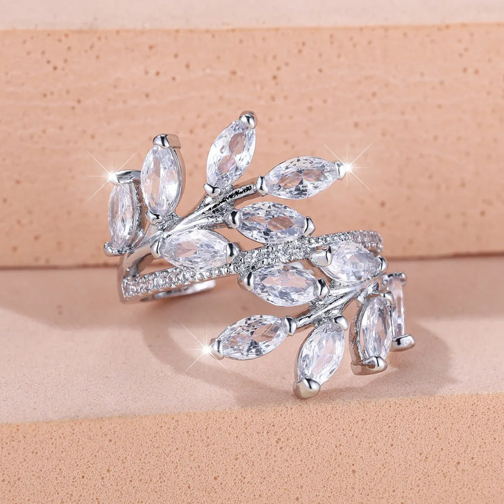 Adjustable copper leaf ring with a central zircon stone on a finger, showing rose gold and platinum colour options.