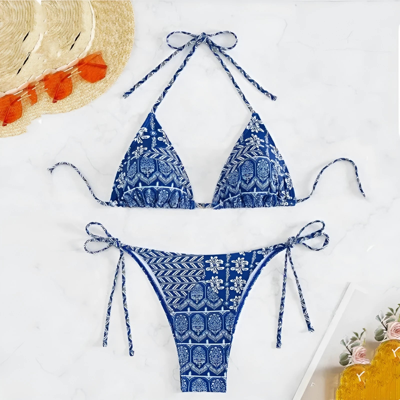 Women's green split bikini swimsuit with bandage-style stitching on a beach.