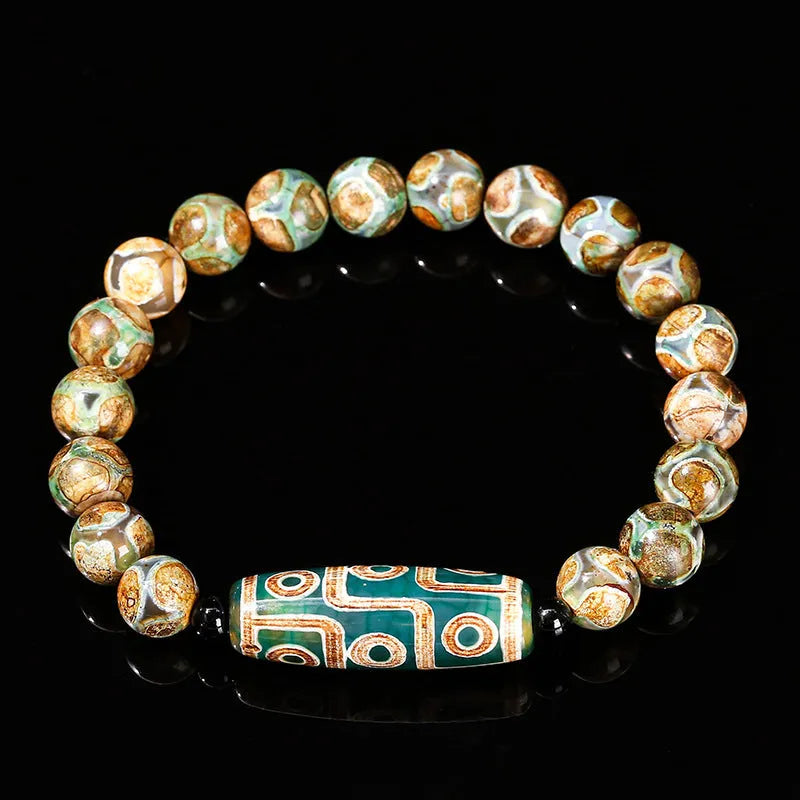 Handmade green dzi bead barrel bracelet with 8mm round geometric beads on a wrist.