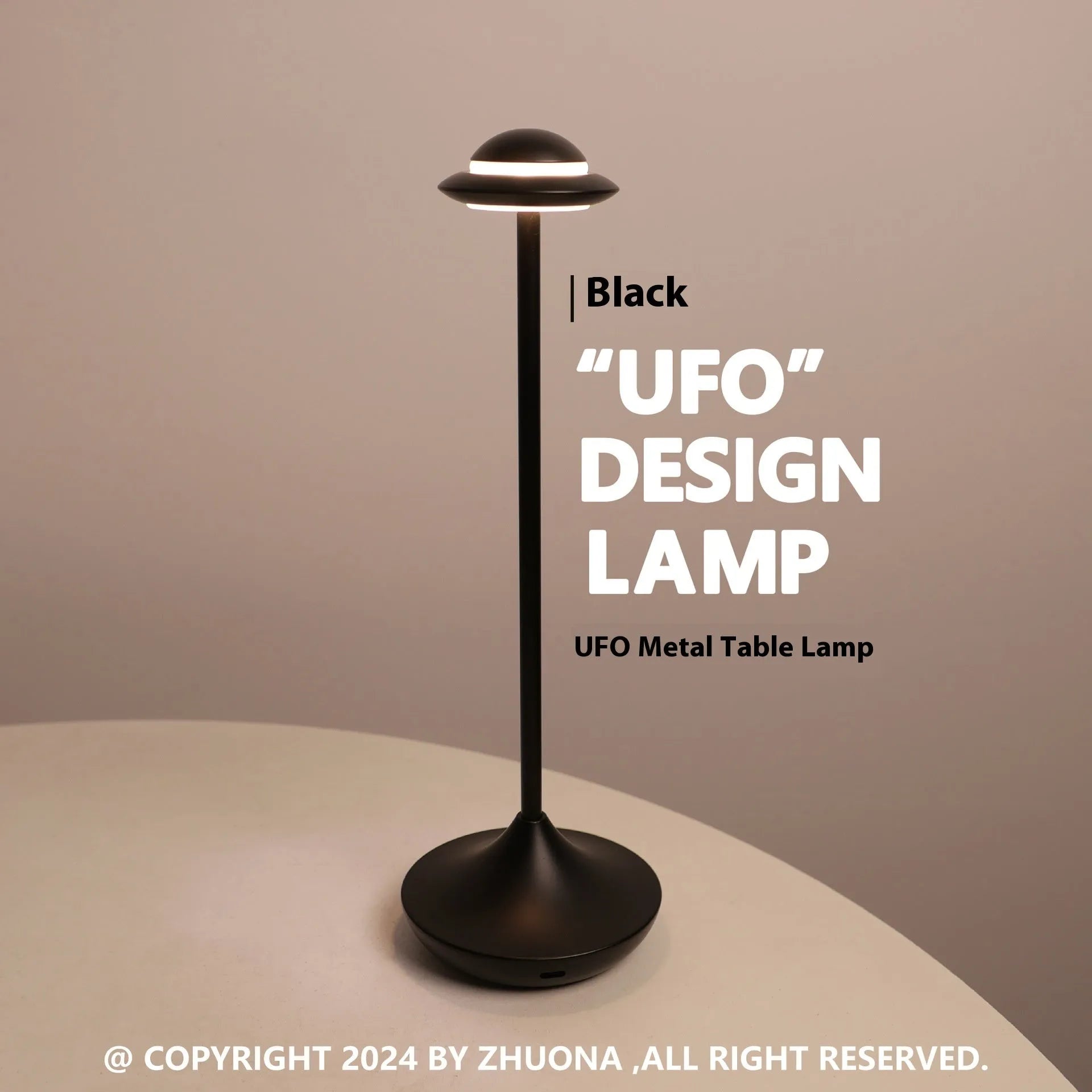 Modern metallic UFO-shaped table lamp with touch base in black, on a wooden desk.