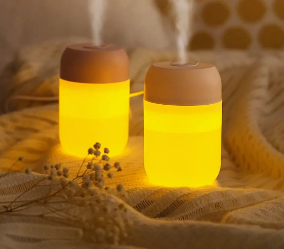 Small white cylindrical USB-powered humidifier with charging cable.