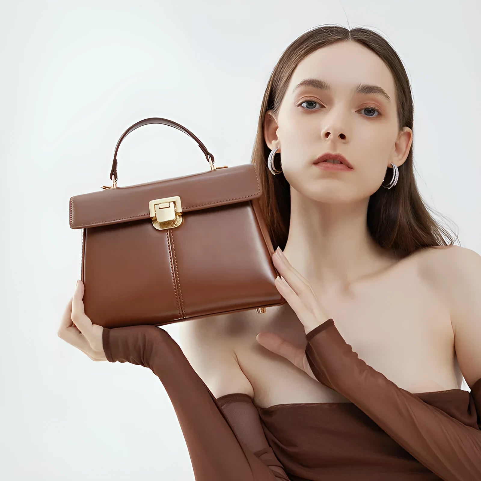 Black genuine leather women's shoulder bag with a vachette clasp, shown next to a dark brown version.