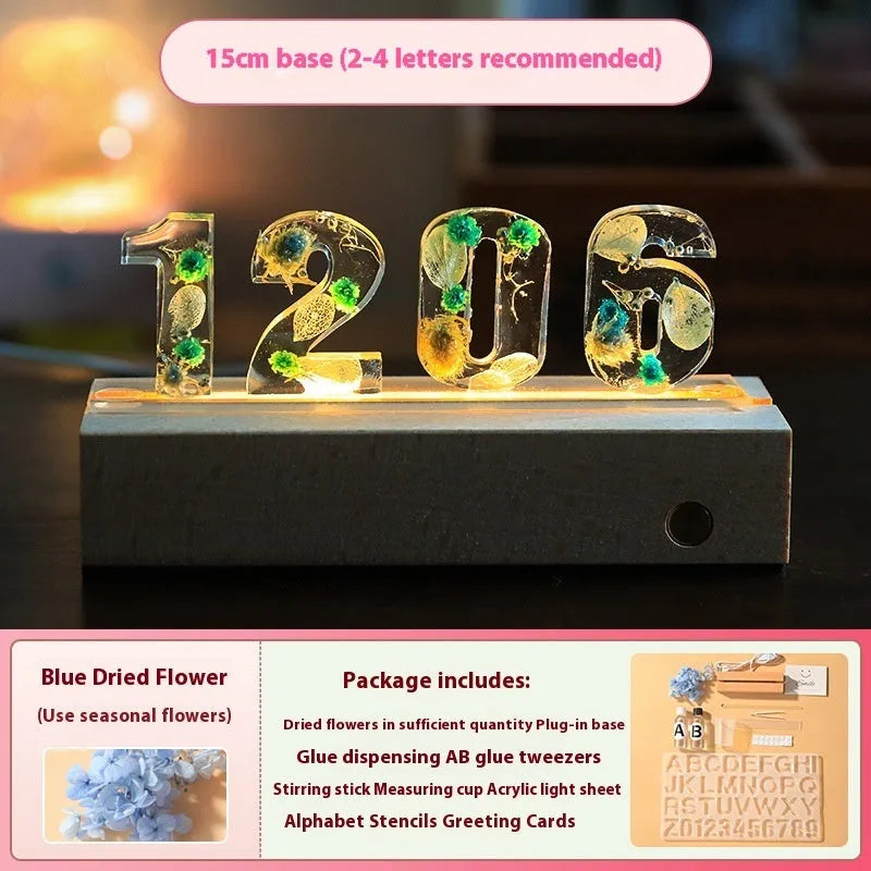 Letter small night lamp with dried flowers, blue colour, warm light, on a table