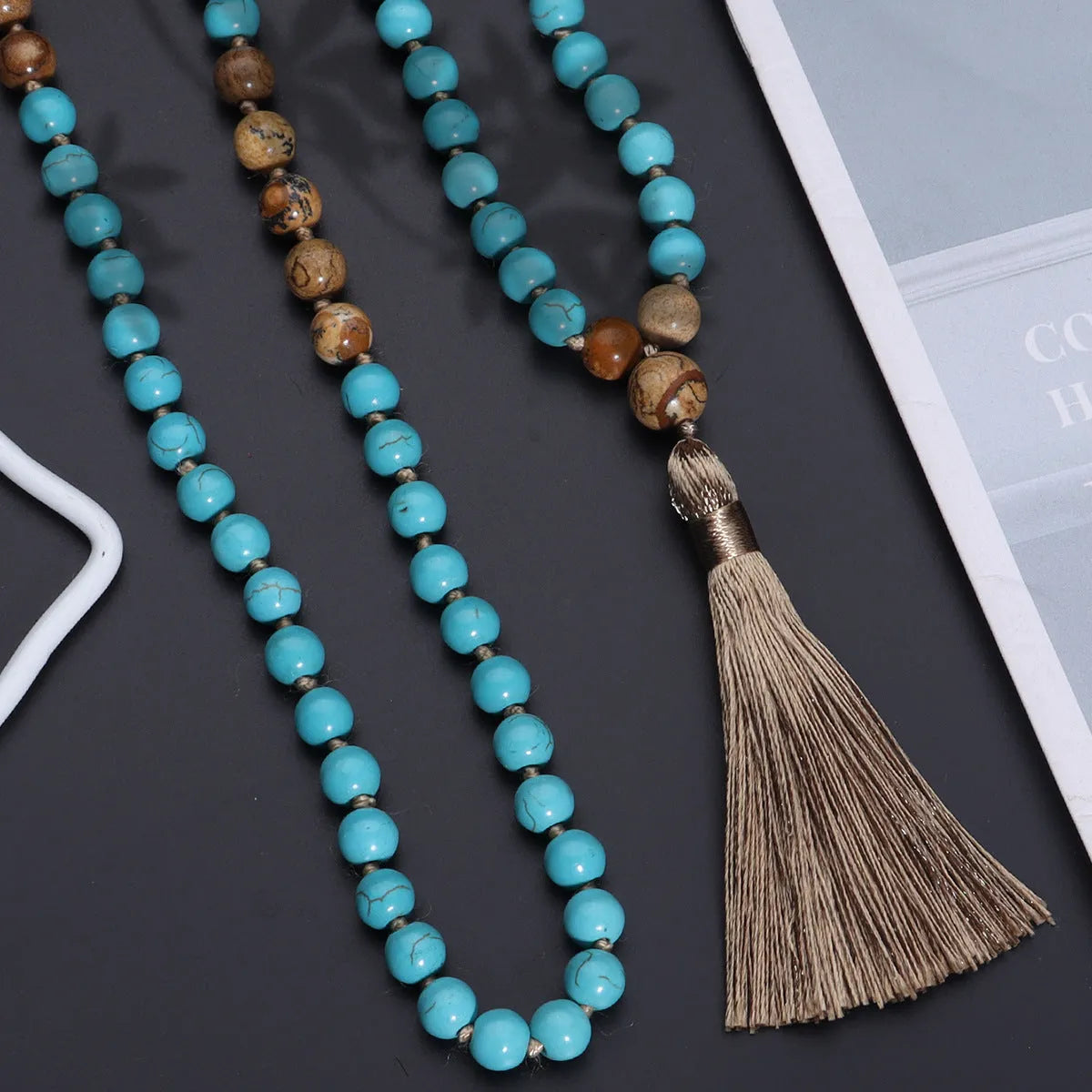 Handmade blue pine turquoise stone mala necklace with ball beads on a white background.