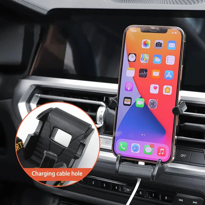 Gold coloured car air vent mobile phone holder with 360-degree rotating head mounted on a car dashboard vent.