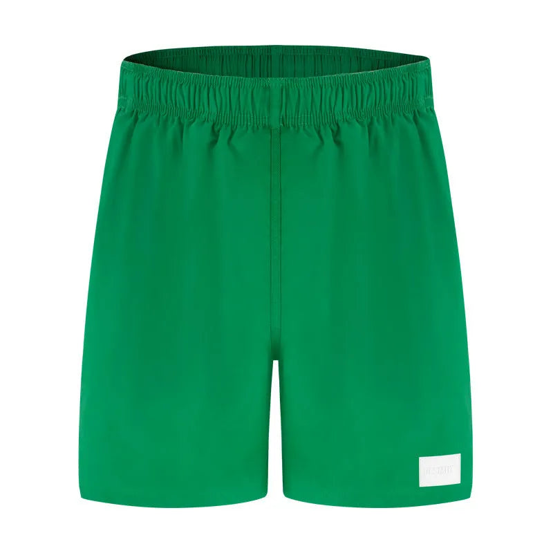 Men's solid colour quick-drying nylon sports shorts on a man, showing straight leg opening.