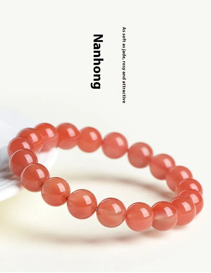 Natural cherry red agate beaded bracelet shown in a single loop, with polished round stones.