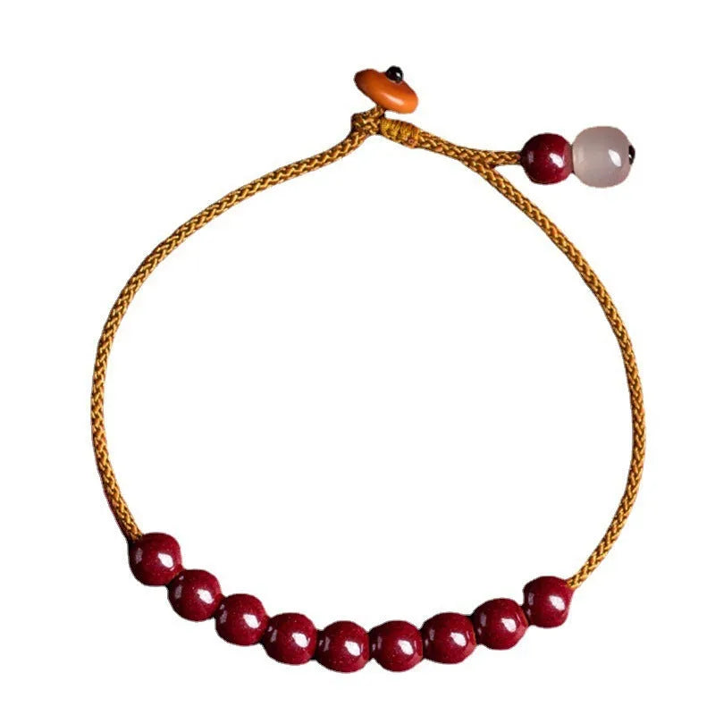 Hand-woven cinnabar and Hetian jade geometric bracelet on wrist showing natural stone textures