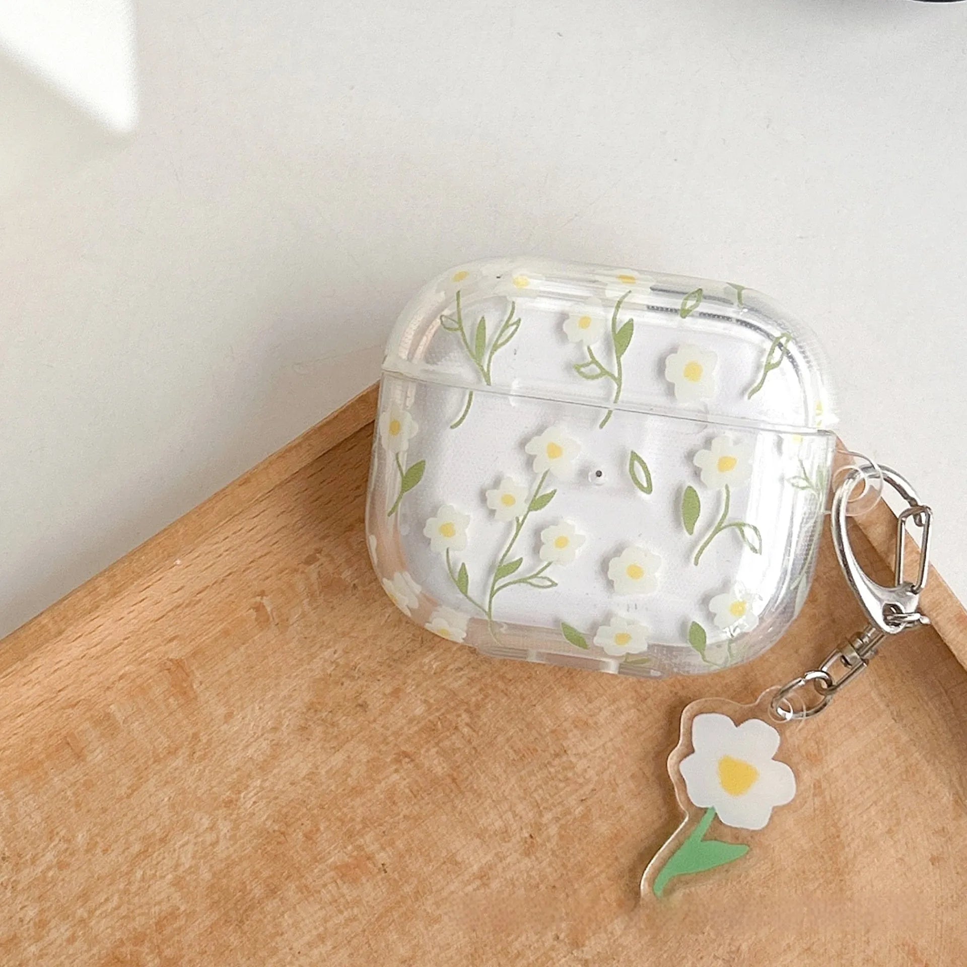 White floral pattern clear TPU protective case for Apple AirPods on a charging case.