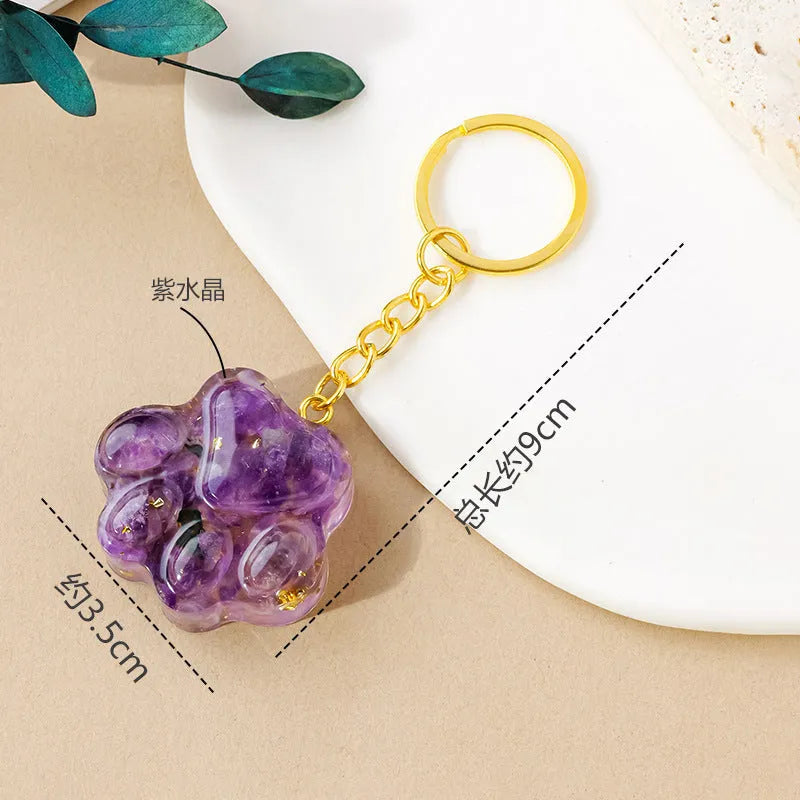 Hand-finished natural crystal cat's paw keychain pendant on a metal ring, showing detailed carving and polished stone surface.