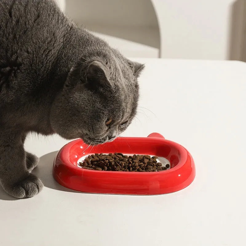 Glazed ceramic pet food bowl with animal design and non-slip rubber base ring.