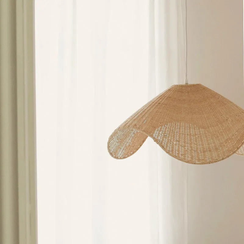 Handmade bamboo rattan chandelier with woven straw and willow lampshade in warm light